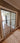 Double hinged glass door with metal frame and handles in modern interior with parquet floor and patterned rug