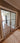 Double hinged glass door with metal frame and handles in modern interior with parquet floor and patterned rug