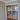 Double hinged glass doors with gold frames and handles in modern interior with wooden herringbone floor