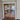 Double hinged glass doors with gold frame in elegant room reflecting bedroom and ocean view