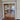 Double hinged glass doors with gold frame in elegant room reflecting bedroom and ocean view