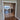 Double hinged glass doors with gold metal frames and geometric design in modern home hallway