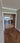 Double hinged glass doors with gold metal frames and geometric design in modern home hallway