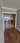 Double hinged glass doors with gold metal frames and geometric design in modern home hallway