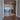 Double hinged glass doors with gold frame and handles leading to a living room with sea view