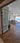Modern double hinged glass door with metal frame opening to living room with sofa and ocean view
