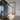 Modern interior with black framed glass hinged door and sliding doors over light wood floor