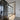 Modern interior with black-framed glass hinged door and light wood flooring