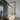 Modern interior with black-framed glass hinged door and light wood flooring