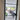 Black framed glass hinged door opening into modern living space with gray chairs and potted plants