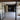 Modern kitchen with dark cabinets, central island, and metal-framed glass double doors