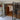 Interior modern room with black framed glass double door and side panels opening to wood floored area with stools and bookshelves
