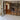 Black metal framed glass double doors with side panels opening to a bright living room with wooden floors