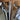 Close-up of modern stainless steel double hinged door handles on glass doors with wooden chairs in background