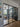 Modern living room separated by black steel frame double glass doors and side panels with wooden floor