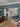 Modern living room with black double glass doors, blue walls, wood flooring, and cozy seating