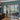 Modern black framed double glass door with two side panels in living room with blue wall and wooden floor