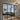 Modern living room with glass double doors featuring black frames, gray sectional sofa, patterned rug