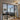 Modern black framed glass double doors with two side panels opening into a cozy living room with a gray sectional sofa and patterned rug
