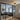 Modern living room with gray sectional sofa, patterned rug, black metal framed glass double doors