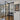 Modern black-framed double glass doors with side panels in a bright hallway with wooden floor and a wall art 'Be Kind to Your Mind'