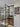 Modern black-framed double glass doors with side panels in a bright hallway with wooden floor and a wall art 'Be Kind to Your Mind'