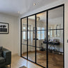 Modern black frame double glass doors with side panels separating living room and entryway