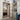Modern double hinged black frame glass door in bright kitchen with built-in bookshelf and tiled floor
