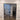 Modern double hinged glass door with black metal frame in interior with wood-look tile flooring