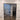 Modern double hinged glass door with black metal frame in interior with wood-look tile flooring