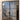 Double hinged black metal frame glass interior doors with modern staircase and wood flooring