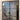 Double hinged black metal frame glass interior doors with modern staircase and wood flooring