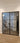 Double hinged black metal frame glass interior doors with modern staircase and wood flooring