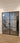 Double hinged black metal frame glass interior doors with modern staircase and wood flooring