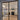 Modern double hinged black metal frame door with glass panels opening to stylish living room
