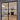 Modern double hinged black frame glass doors opening to elegant living room with fireplace and chandelier