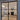 Modern double hinged black frame glass doors opening to elegant living room with fireplace and chandelier