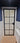 Frosted glass hinged door with black metal frame in modern blue and white bathroom