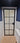 Frosted glass hinged door with black metal frame in modern blue and white bathroom
