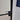 Modern hinged black metal frame door with frosted glass and black handle in tiled room