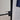 Modern hinged black metal frame door with frosted glass and black handle in tiled room
