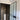 Modern bathroom with frosted glass hinged door, black frame, and tall white pedestal sink