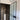 Modern bathroom with frosted glass hinged door, black frame, and tall white pedestal sink