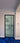 Modern black framed hinged glass door with white wall and blue carpet flooring in interior
