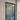 Modern black framed glass hinged door with metal handle, blue carpeted floor, and white walls