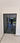 Modern double hinged black metal frame glass door with reflective surface in bright interior