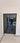 Modern double hinged black metal frame glass door with reflective surface in bright interior