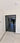 Modern double hinged black framed glass door with grid pattern, white walls, marble floor with patterned border
