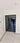 Modern double hinged black framed glass door with grid pattern, white walls, marble floor with patterned border