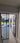 Modern interior with double hinged black framed glass doors opening to a sunlit garden patio